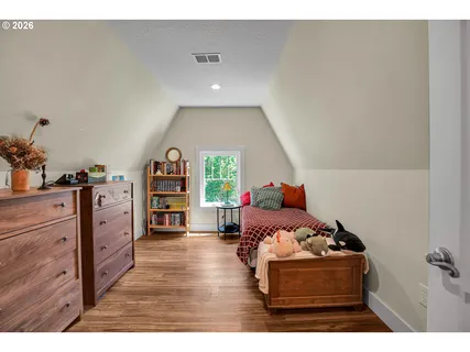 a bedroom with furniture and a wooden floor