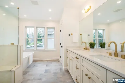 a bathroom with a sink a toilet a mirror and shower