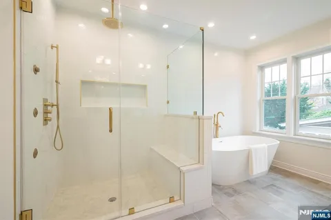 a white bath tub sitting in a bathroom next to a window