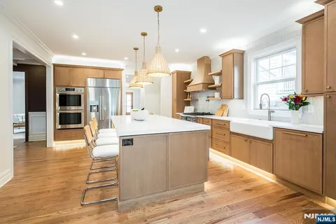 a large kitchen with stainless steel appliances kitchen island a large counter top a stove and a sink