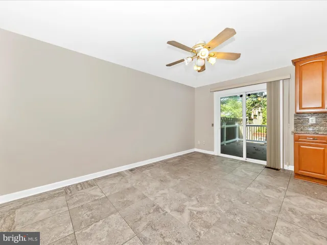 an empty room with windows and ceiling fan