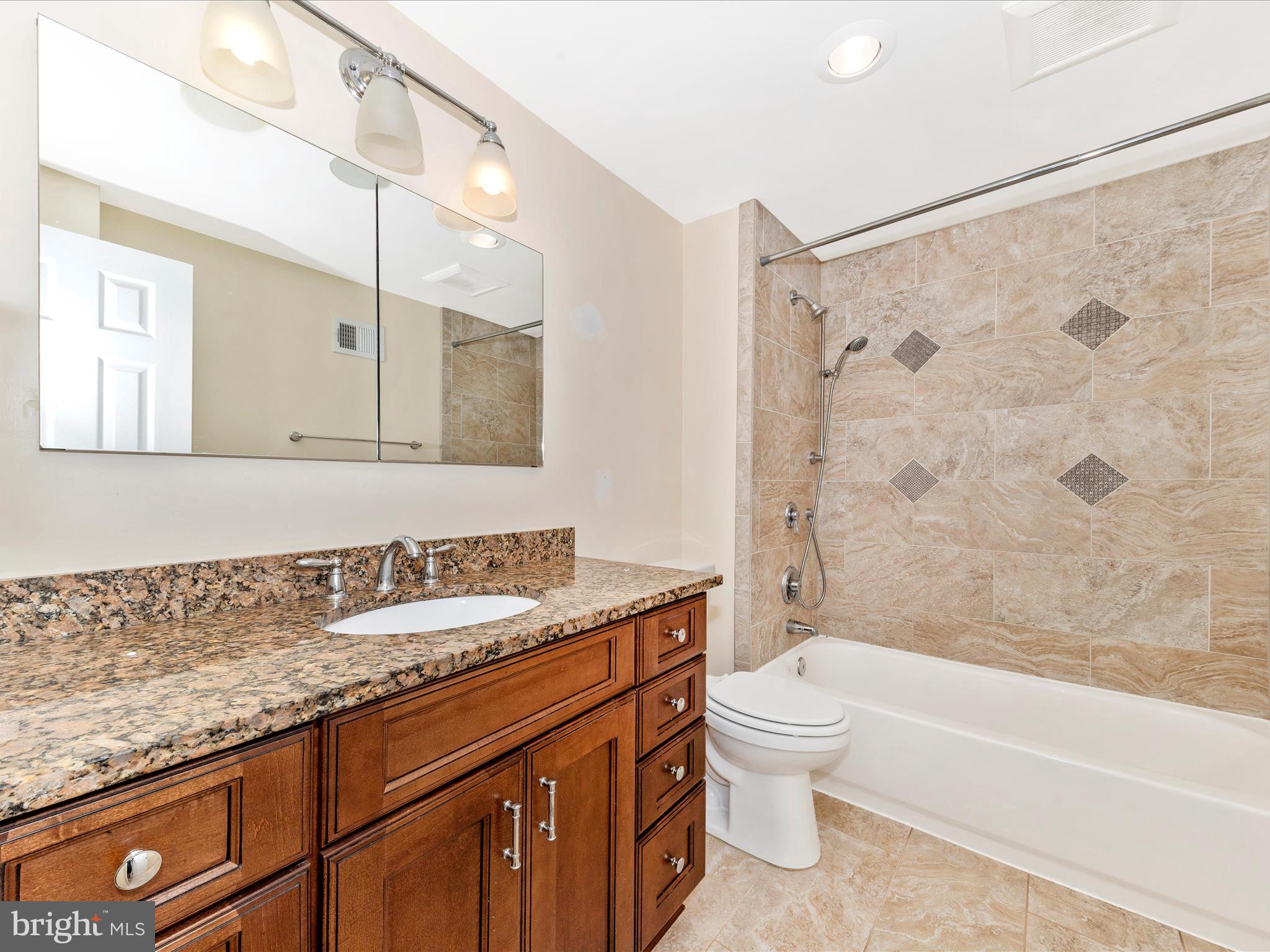 314 Crescendo Way Silver Spring, MD 20901 - Photo 26 of 57 a bathroom with a granite countertop sink a toilet and a bathtub