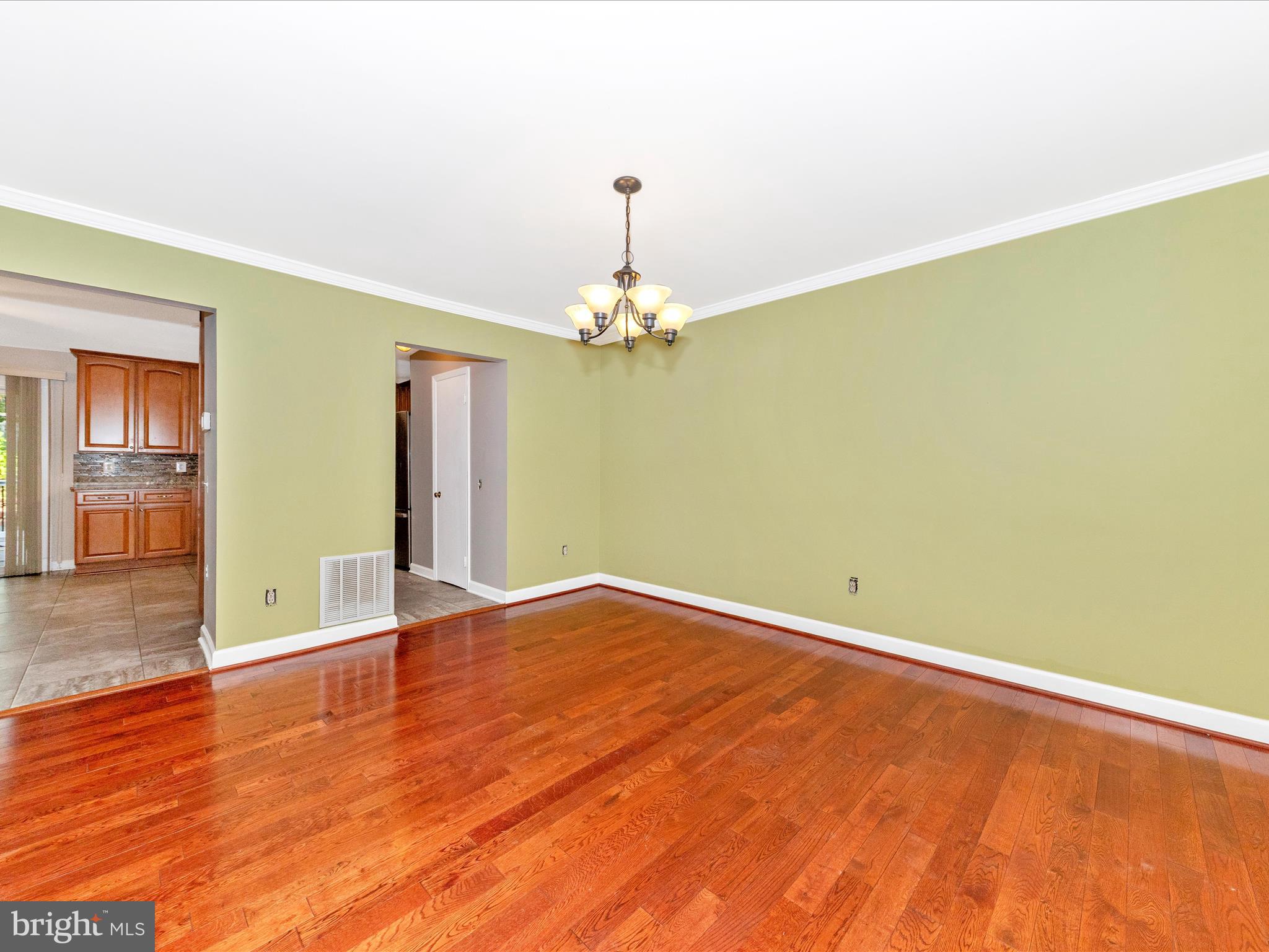314 Crescendo Way Silver Spring, MD 20901 - Photo 10 of 57 an empty room with wooden floor chandelier fan and windows