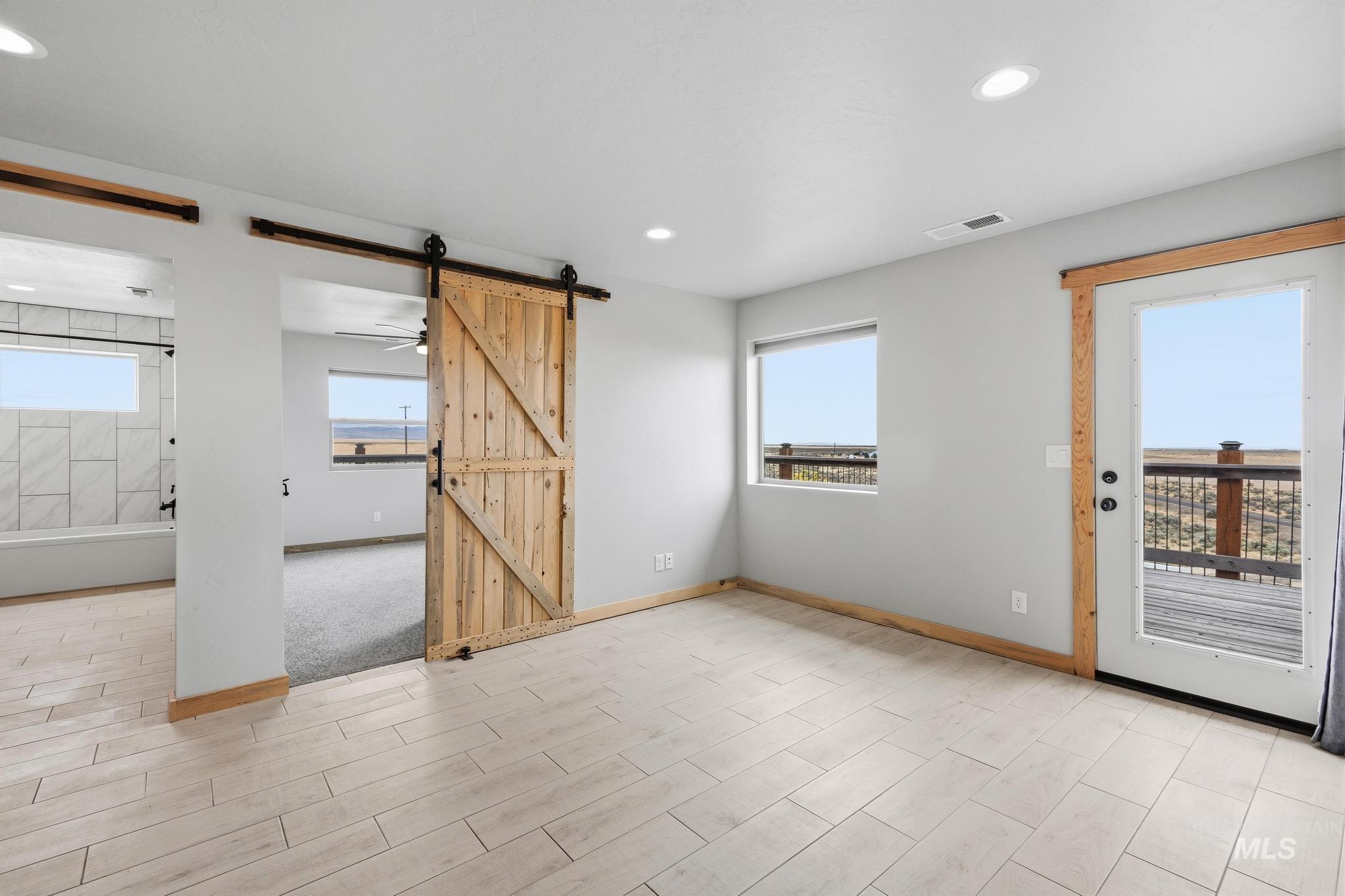 870 Desert Wind Road Boise, ID 83716 - Photo 32 of 50 Spacious interior featuring wood-finish tile flooring, recessed lighting, and a prominent barn door