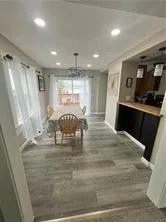a kitchen with kitchen island granite countertop a refrigerator and a sink