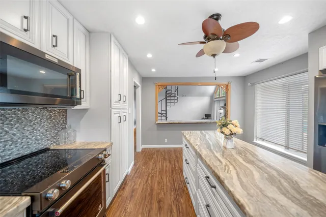 a kitchen with a stove and a wooden floor