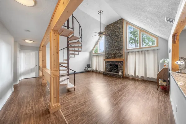 a view of a livingroom with wooden floor and a fireplace