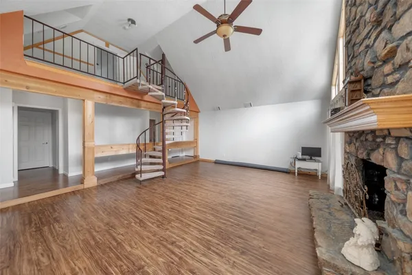 a view of a livingroom with wooden floor a fireplace and window