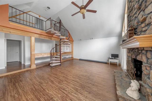 a view of a livingroom with wooden floor a fireplace and window