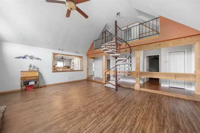 a view of a livingroom with wooden floor and a ceiling fan