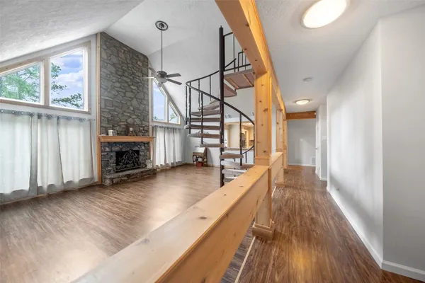 a view of a living room with wooden floor and a fireplace
