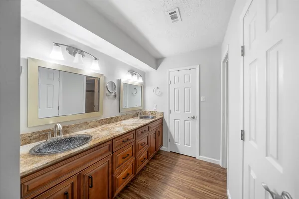 a spacious bathroom with a granite countertop double vanity sink a mirror and
