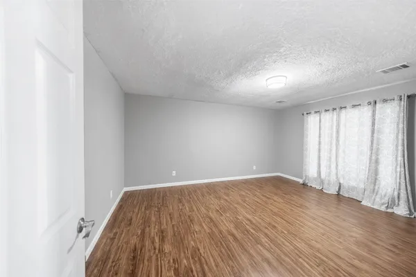 a view of room with window and wooden floor