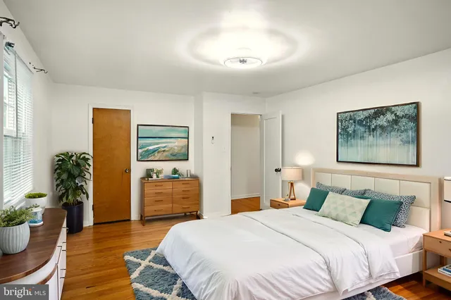 a bedroom with bed and wooden floor