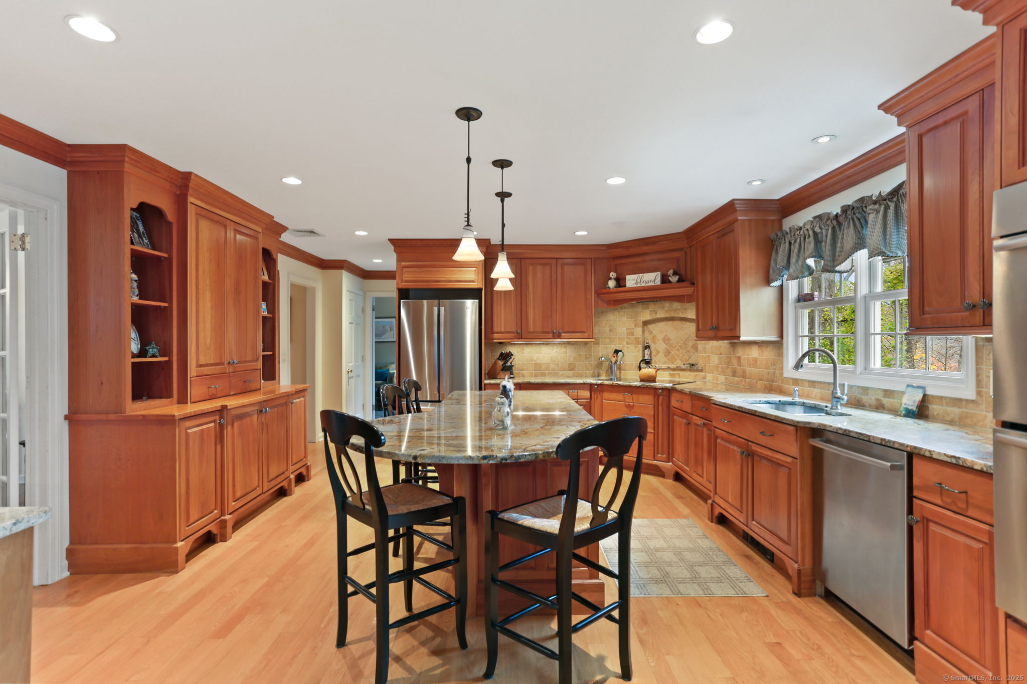41 Calvin Road Wilton, CT 06897 - Photo 11 of 34 a kitchen with stainless steel appliances kitchen island granite countertop a table chairs sink and cabinets