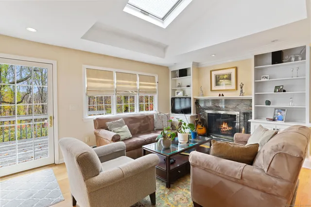 a living room with furniture a fireplace and a large window
