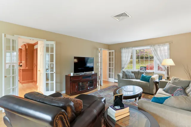 a living room with furniture a flat screen tv and a large window