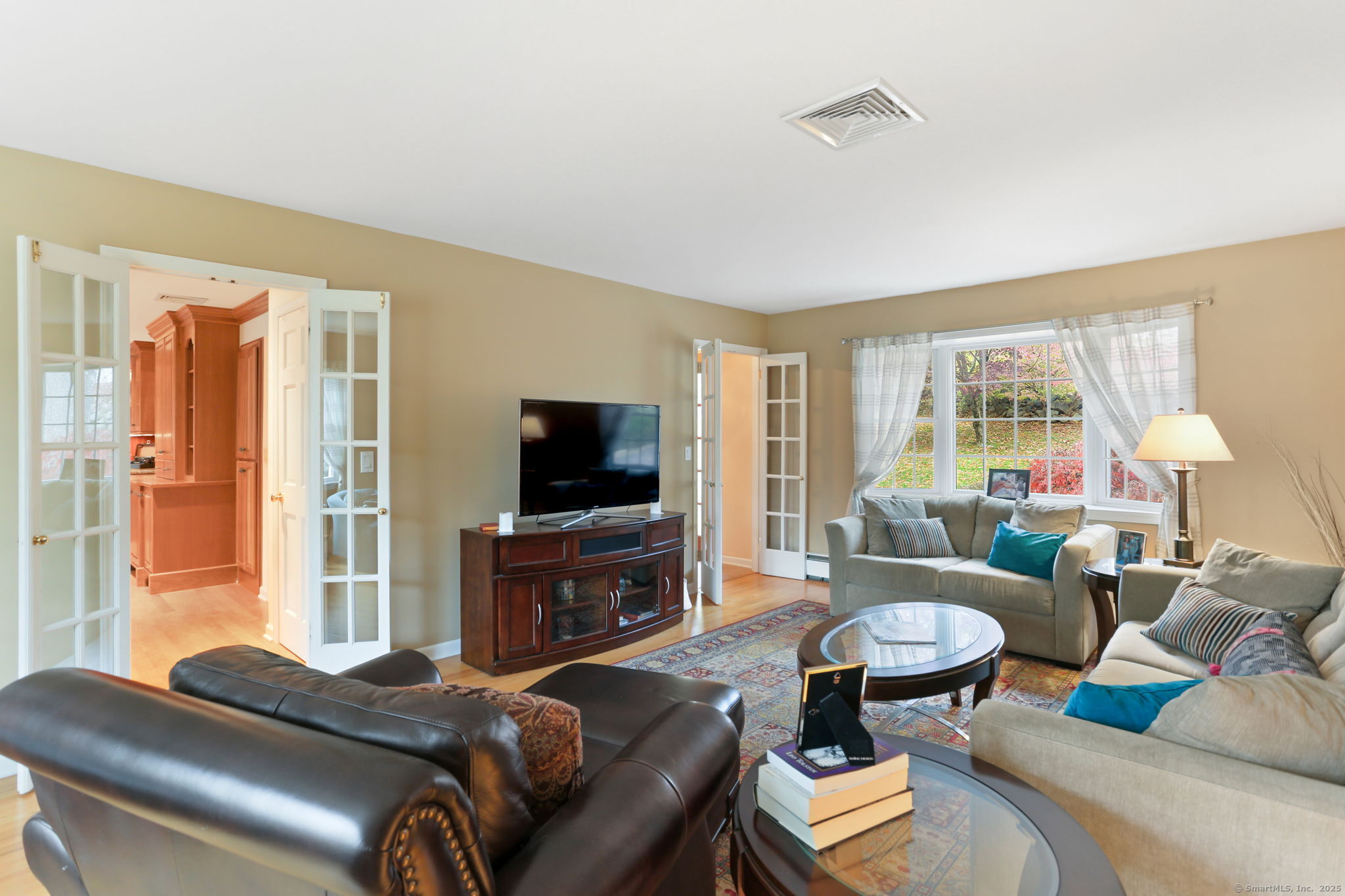 41 Calvin Road Wilton, CT 06897 - Photo 7 of 34 a living room with furniture a flat screen tv and a large window