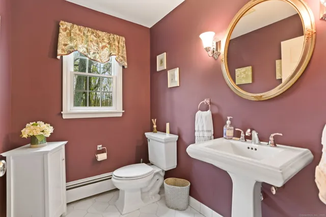 a bathroom with a toilet a sink and a mirror