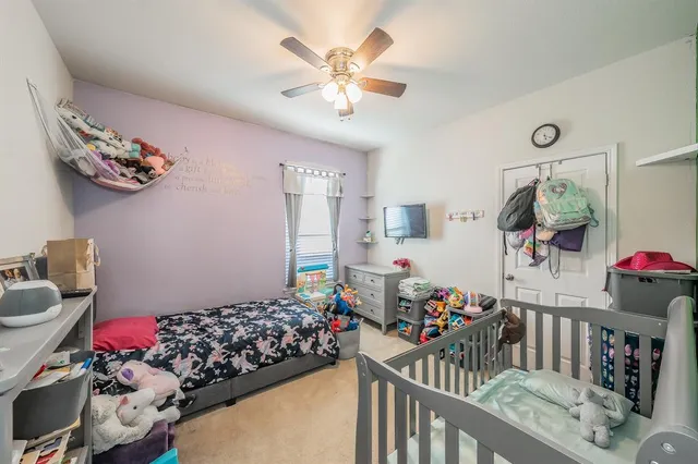 a bedroom with furniture a rug and a chandelier fan