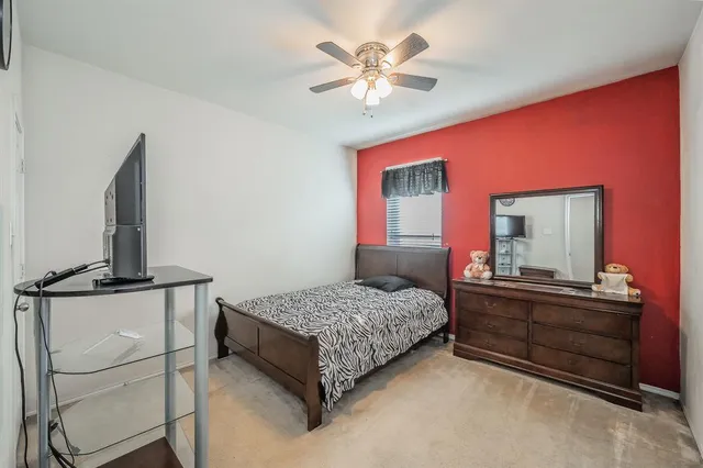 a bedroom with a bed dresser and flat screen tv