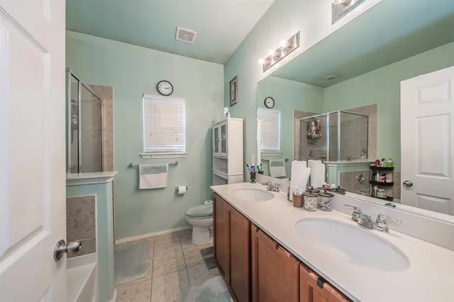 a bathroom with a double vanity sink mirror and toilet