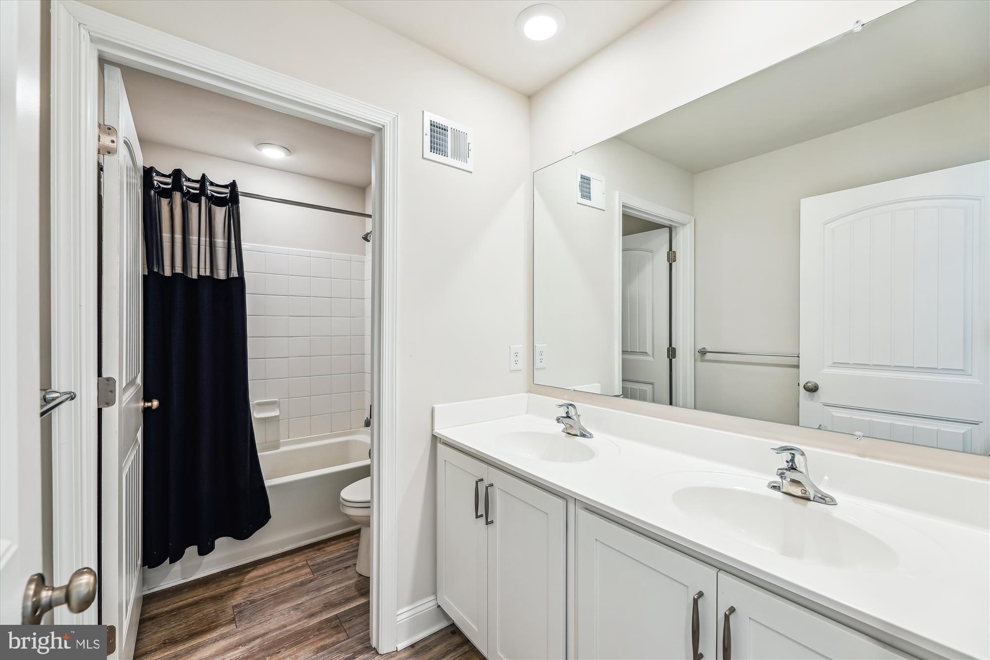 31131 Tigress Road Lewes, DE 19958 - Photo 24 of 45 a bathroom with a double vanity sink a mirror and a shower