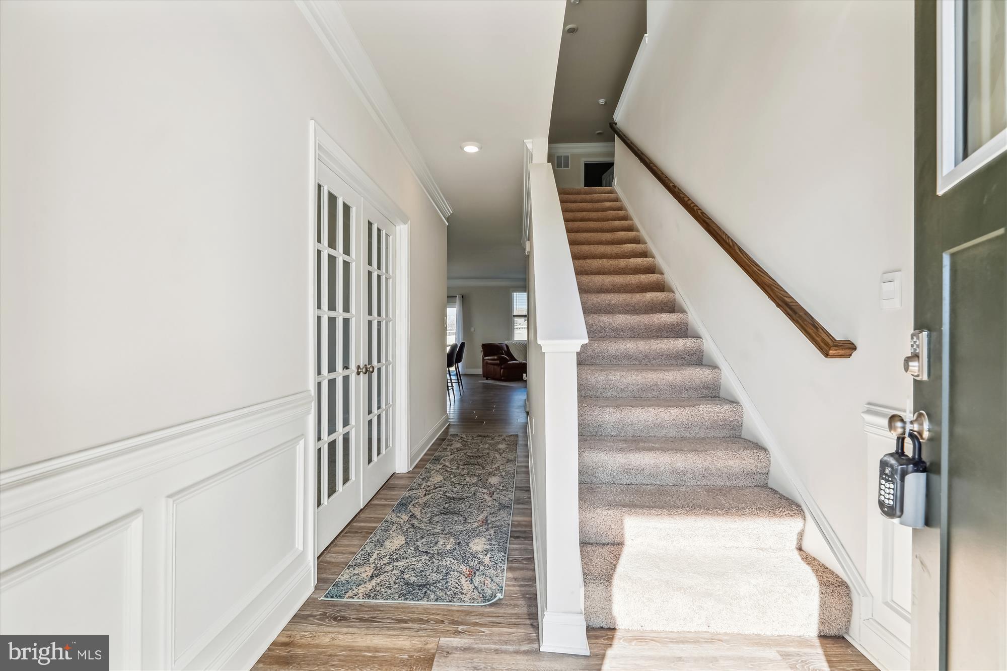 31131 Tigress Road Lewes, DE 19958 - Photo 4 of 45 a view of staircase with lots of frames on wall and wooden floor