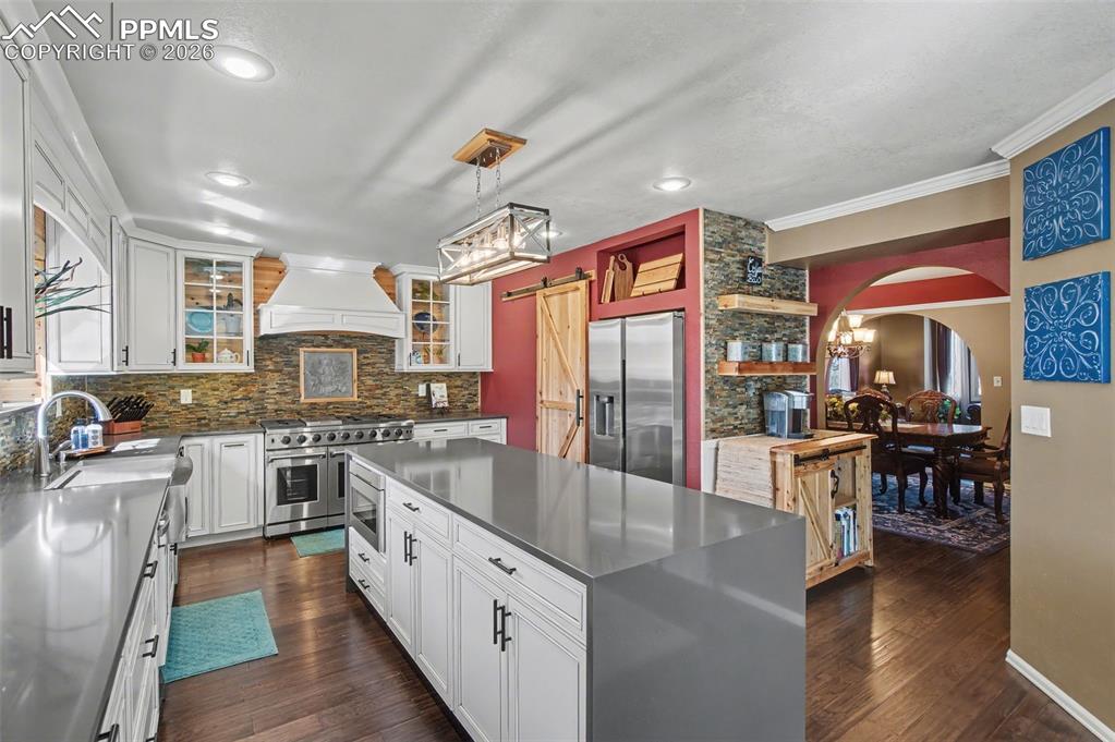 1375 Blueberry Hills Road Monument, CO 80132 - Photo 11 of 50 a large kitchen with stainless steel appliances granite countertop a stove top oven a sink dishwasher and cabinets with wooden floor