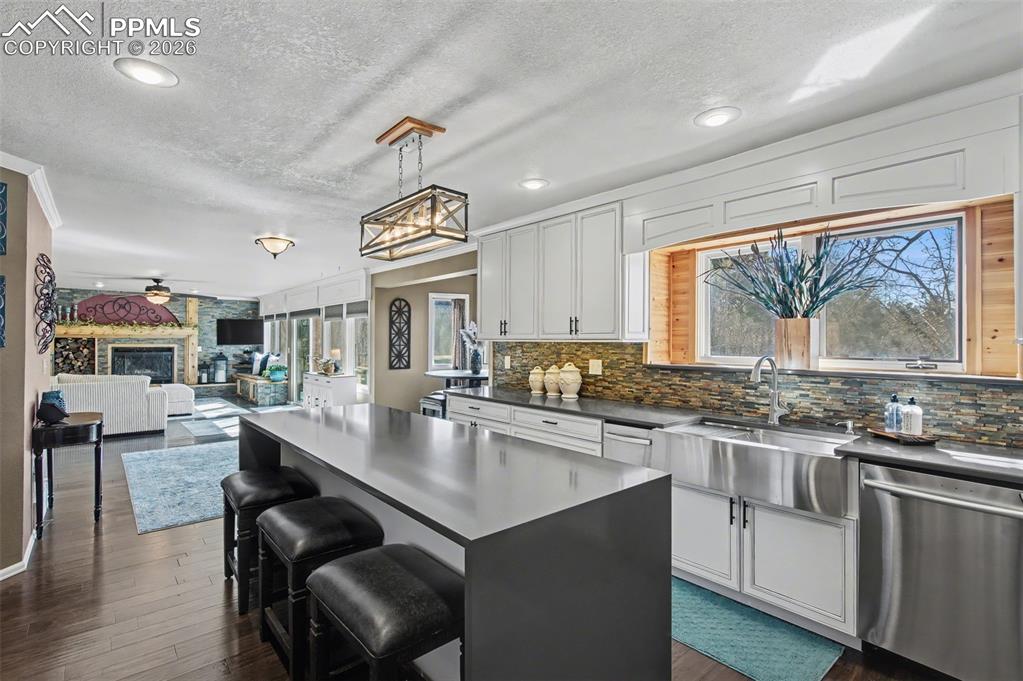 1375 Blueberry Hills Road Monument, CO 80132 - Photo 14 of 50 a kitchen with stainless steel appliances granite countertop a stove top oven a sink dishwasher and chairs with wooden floor