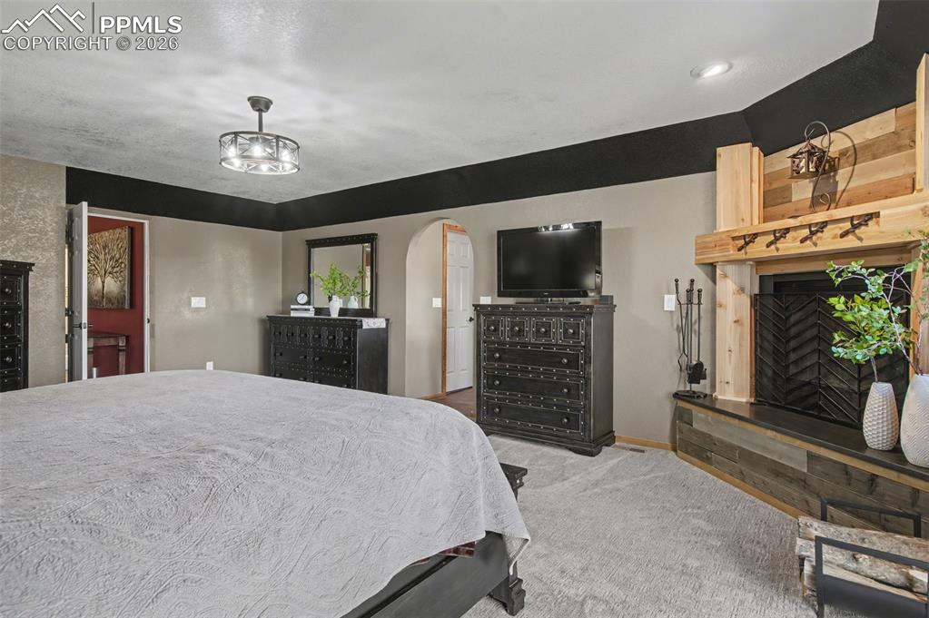 1375 Blueberry Hills Road Monument, CO 80132 - Photo 28 of 50 a spacious bedroom with a bed and a flat screen tv