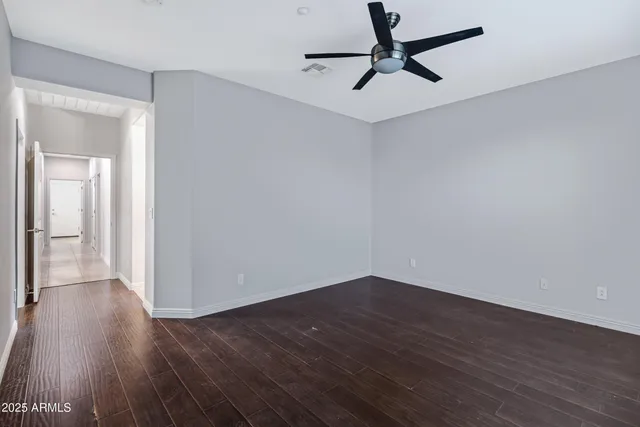 a view of a room with wooden floor and a ceiling fan