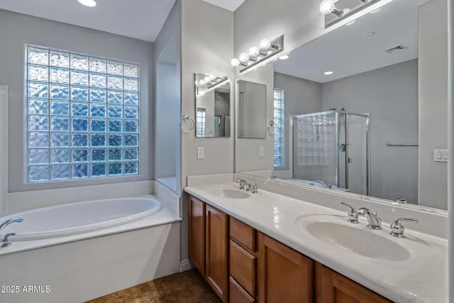 a bathroom with a tub double sink shower and mirror
