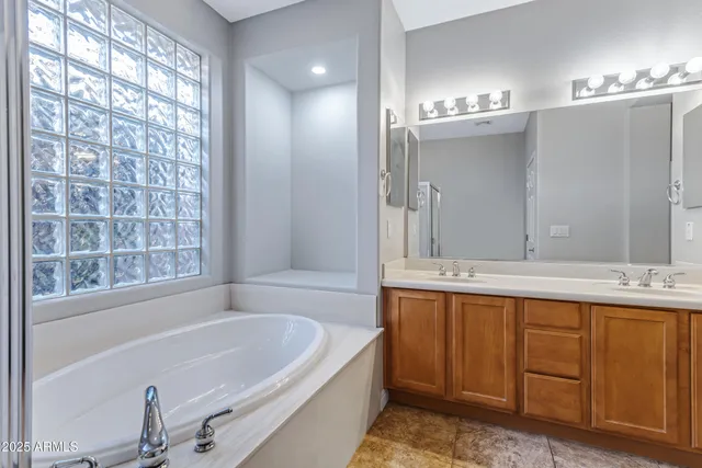 a bathroom with a tub sink and mirror