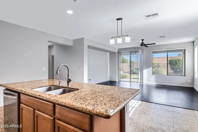 a kitchen with kitchen island granite countertop a sink cabinets and window