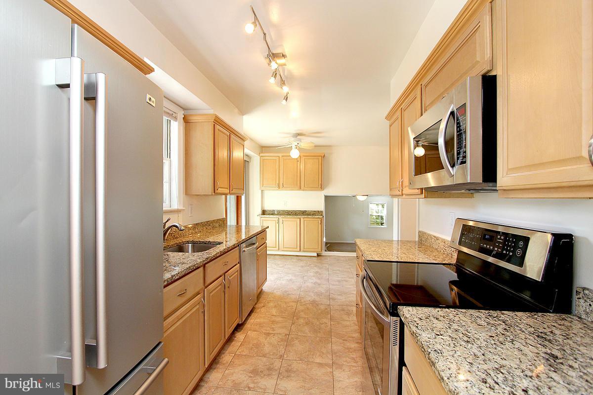 6209 Redwing Road Bethesda, MD 20817 - Photo 13 of 27 a kitchen with stainless steel appliances granite countertop a stove and a refrigerator