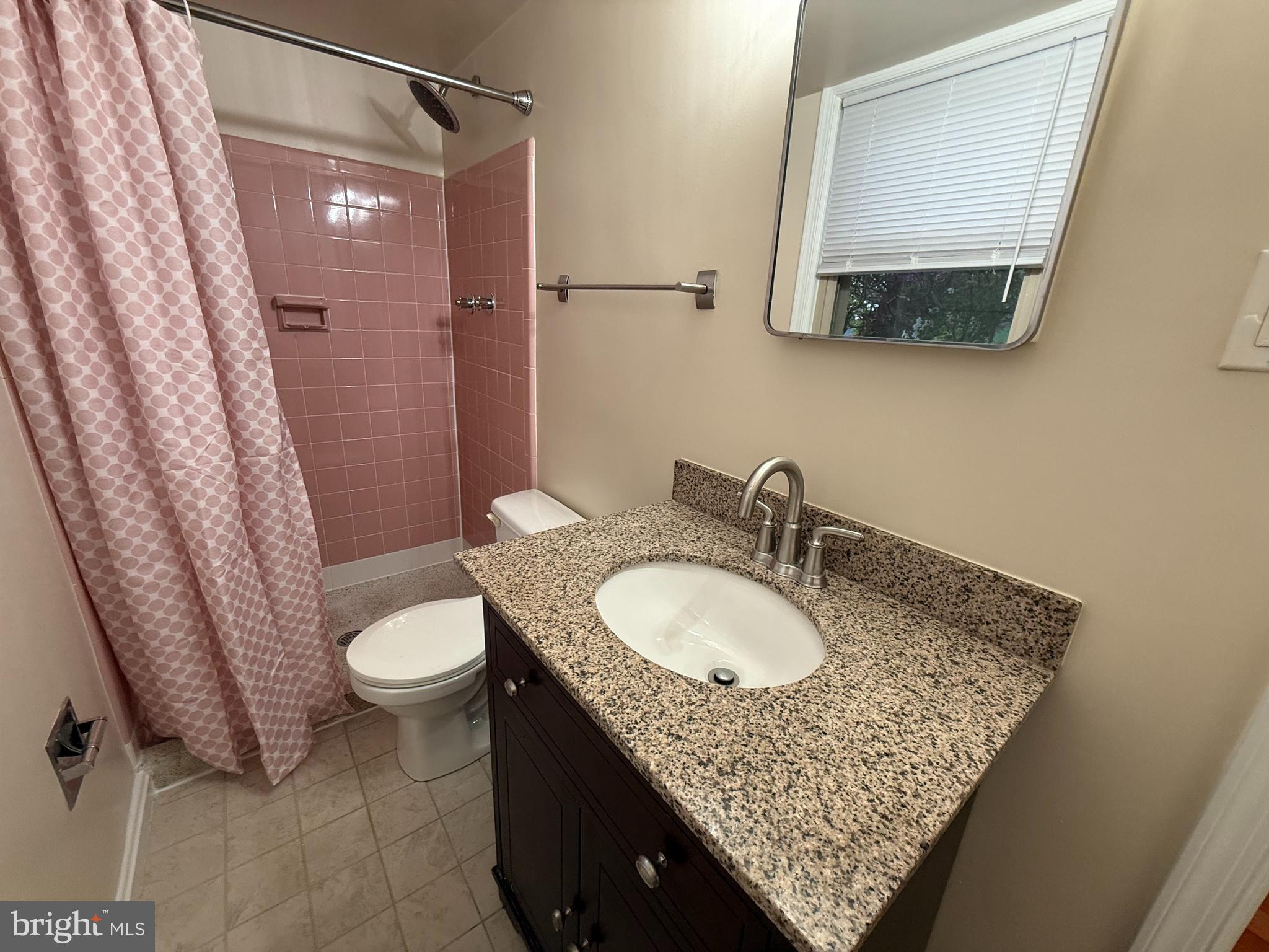 6209 Redwing Road Bethesda, MD 20817 - Photo 21 of 27 a bathroom with a granite countertop sink a mirror and a toilet