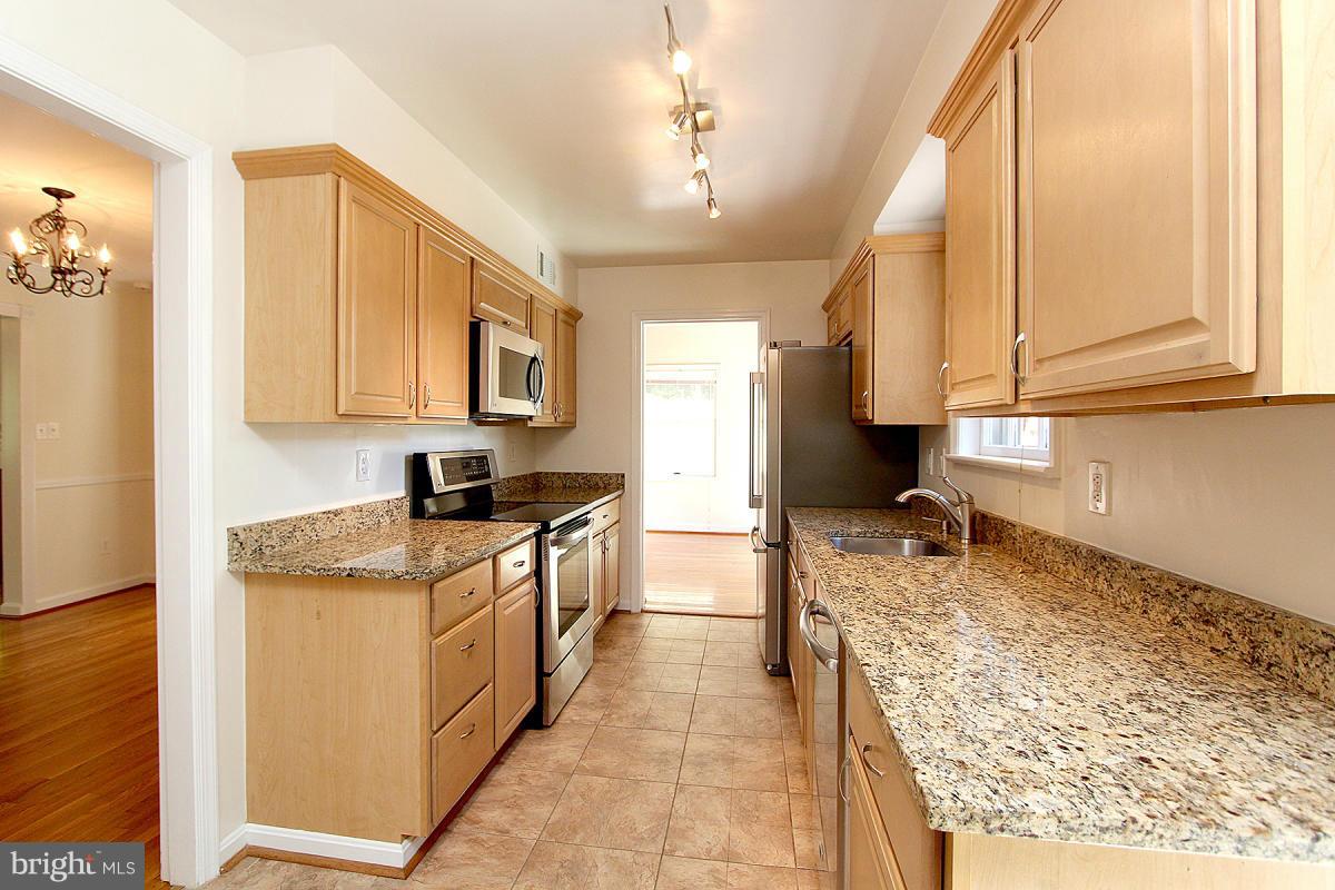 6209 Redwing Road Bethesda, MD 20817 - Photo 10 of 27 a kitchen with stainless steel appliances granite countertop a stove a sink and a refrigerator