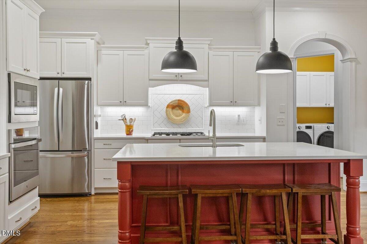 904 Prairie Smoke Street Wake Forest, NC 27587 - Photo 13 of 61 a kitchen with stainless steel appliances granite countertop a stove a refrigerator and a wooden cabinets
