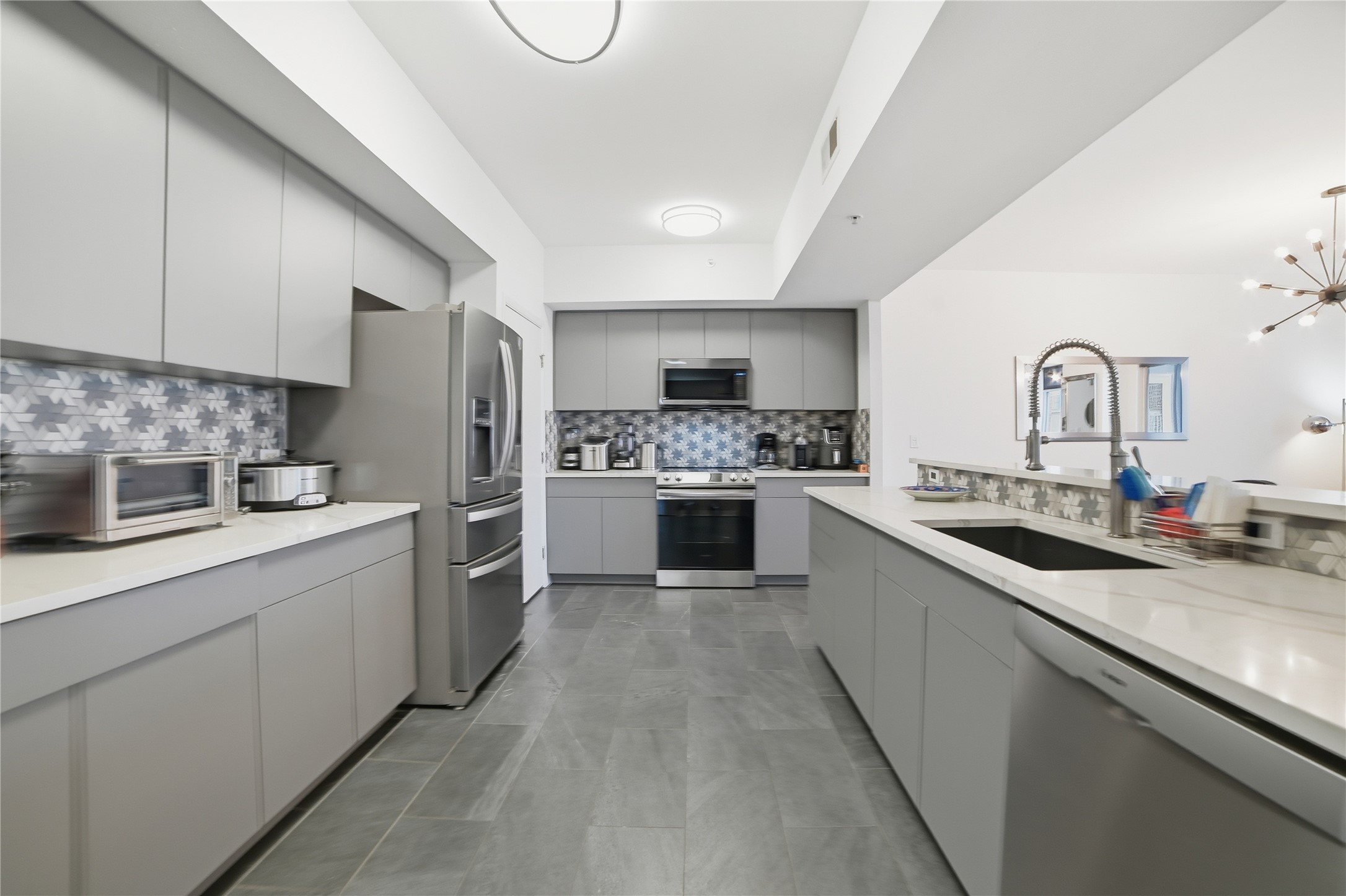 54 Rainey Street, Unit 1018 Austin, TX 78701 - Photo 8 of 32 a kitchen with stainless steel appliances granite countertop a sink a stove top oven and cabinets