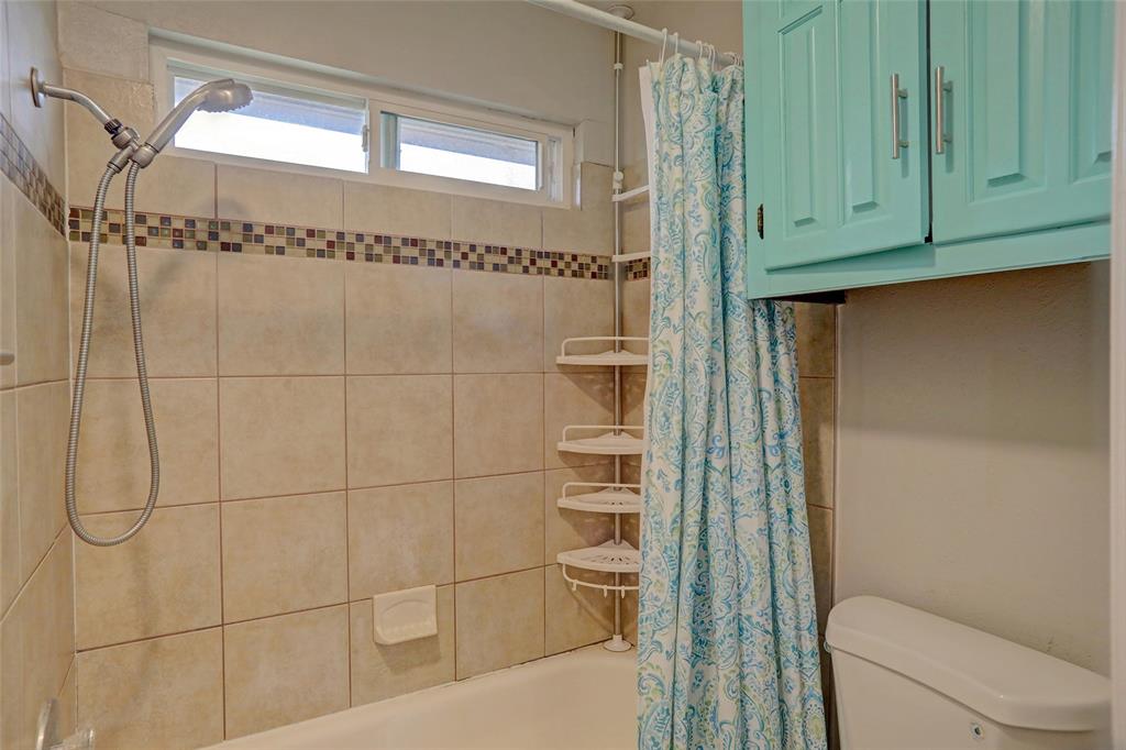 2102 Apollo Road Richardson, TX 75081 - Photo 17 of 26 Bathtub shower combination with tan tile surround, mosaic accent band, and a multi-setting showerhead