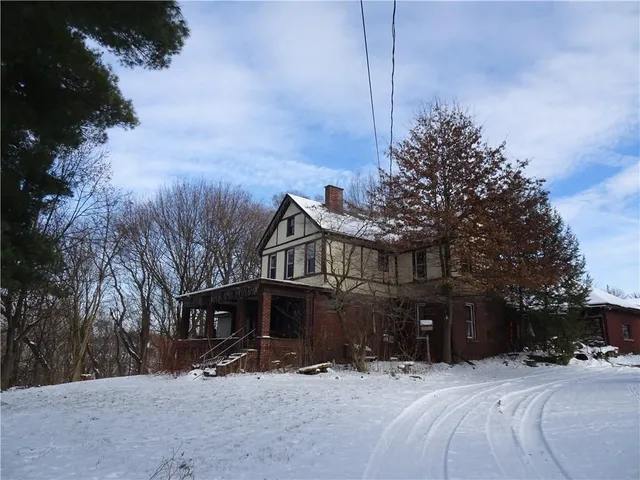 a front view of a house with a yard covered in snow