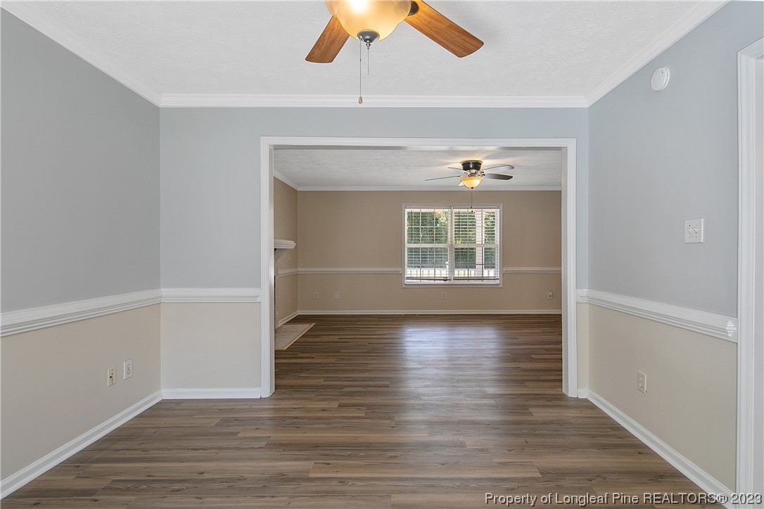 624 Porter Road Hope Mills, NC 28348 - Photo 13 of 45 an empty room with wooden floor chandelier fan and windows