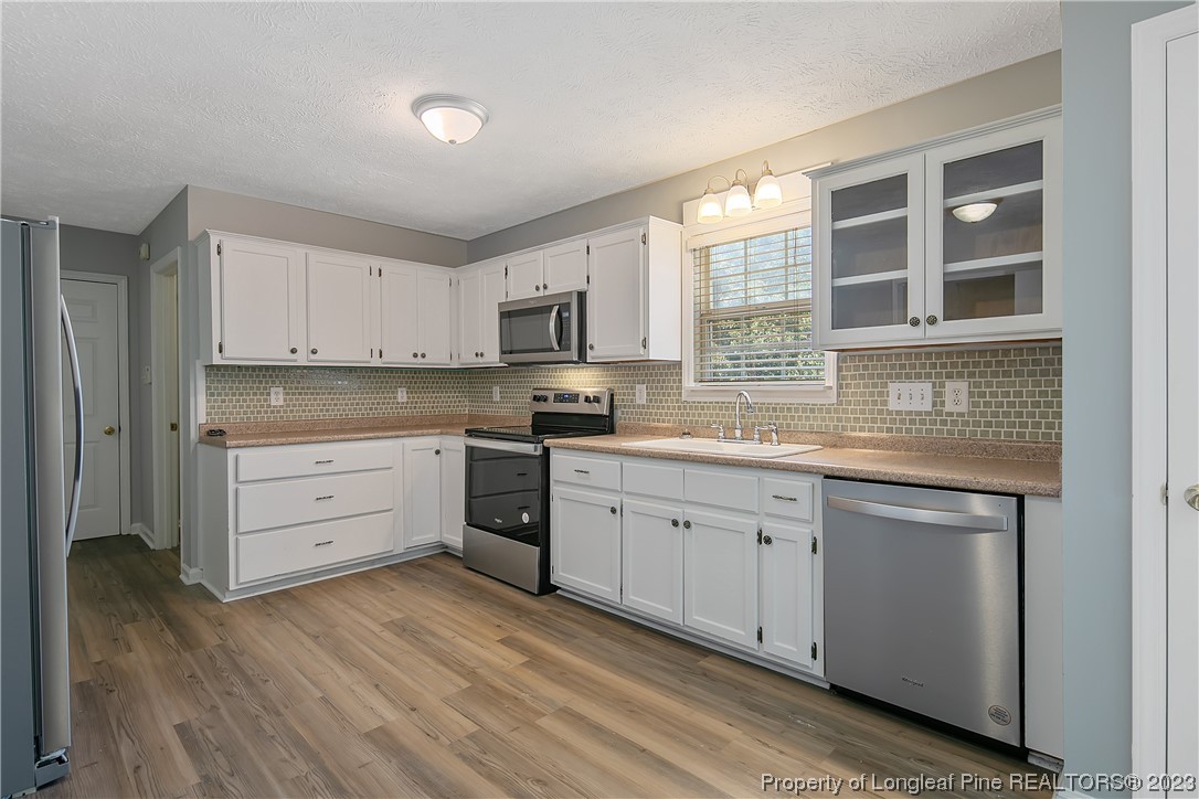 624 Porter Road Hope Mills, NC 28348 - Photo 16 of 45 a kitchen with granite countertop white cabinets and stainless steel appliances