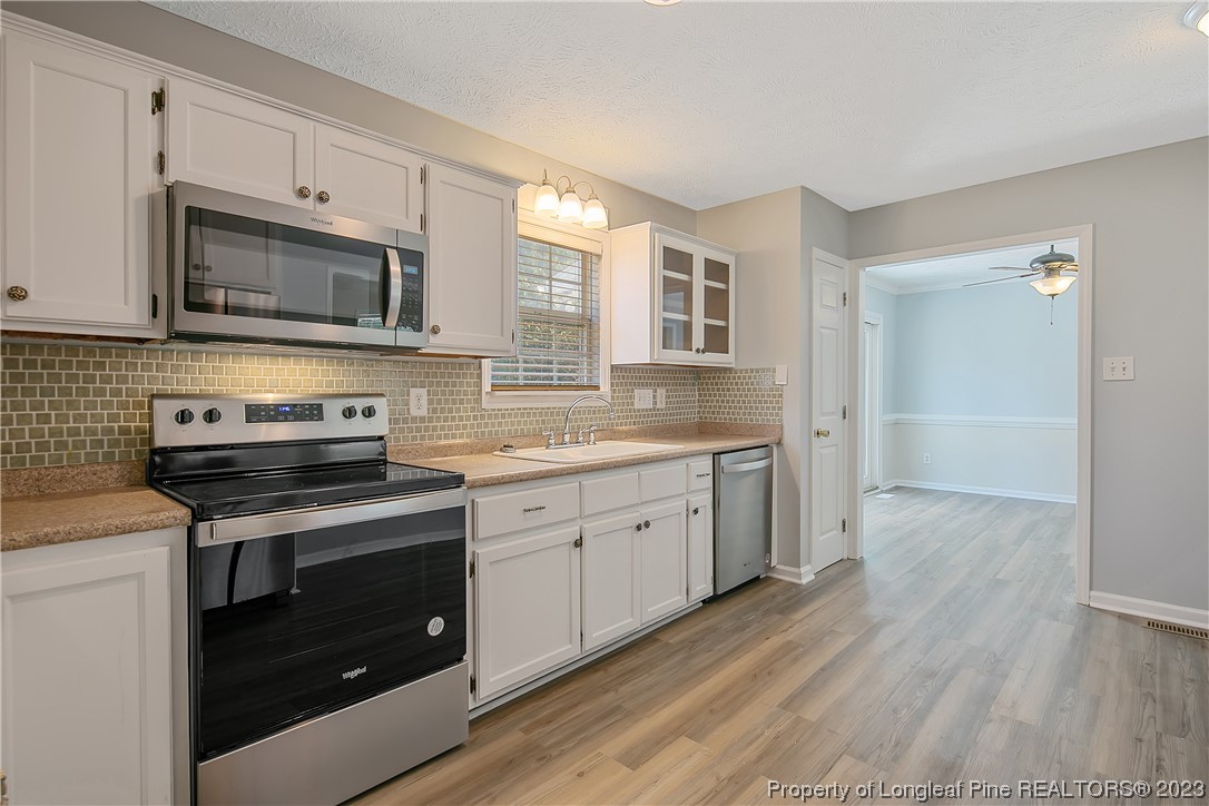 624 Porter Road Hope Mills, NC 28348 - Photo 17 of 45 a kitchen with granite countertop cabinets stainless steel appliances and wooden floor