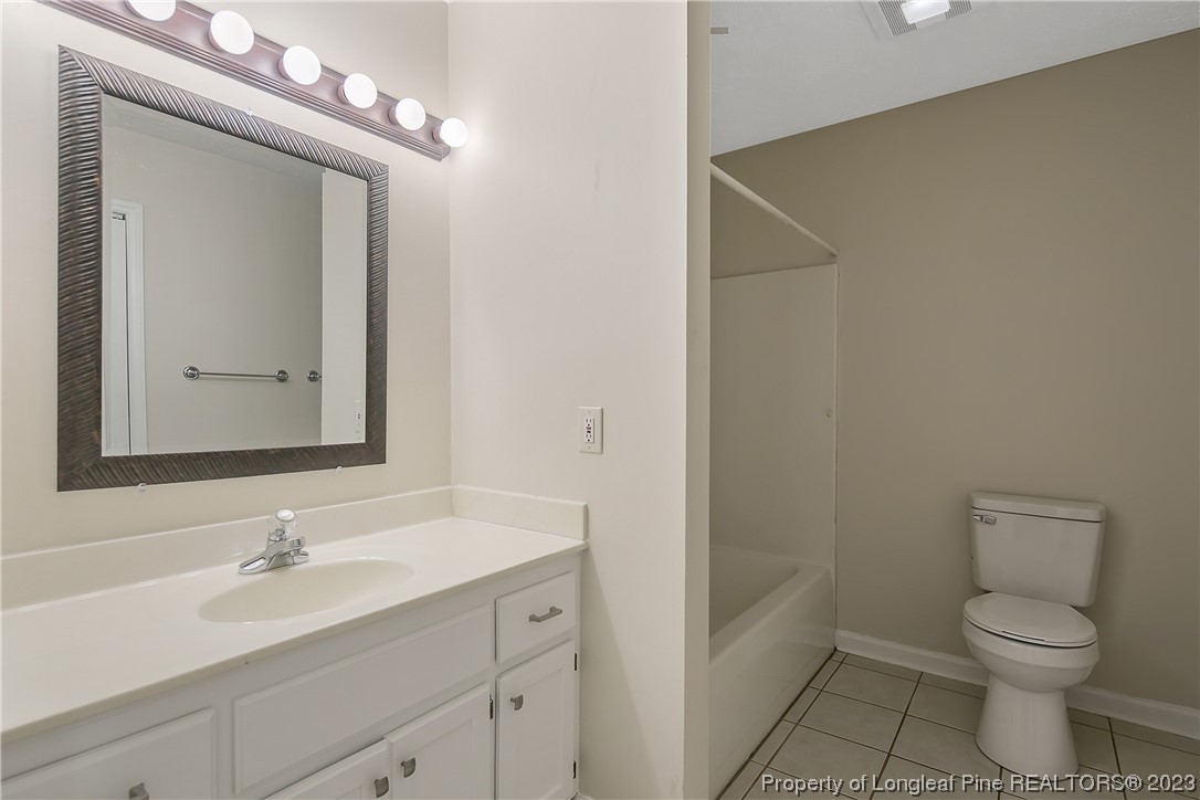 624 Porter Road Hope Mills, NC 28348 - Photo 34 of 45 a bathroom with a toilet a sink a mirror and vanity