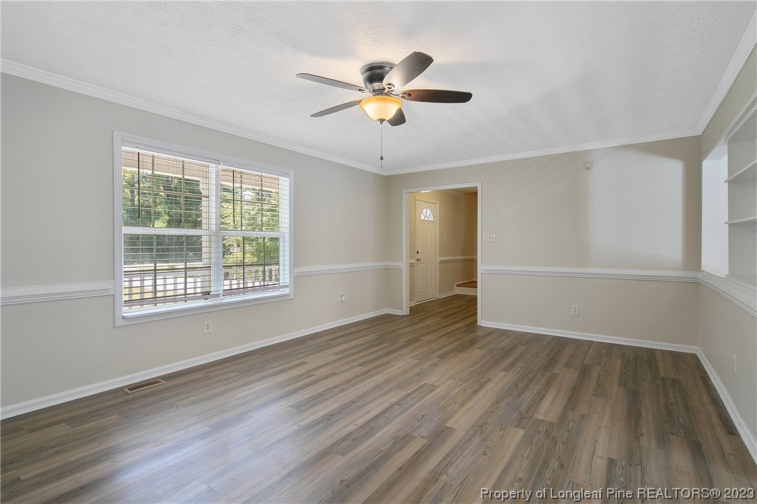 624 Porter Road Hope Mills, NC 28348 - Photo 9 of 45 an empty room with wooden floor chandelier fan and windows
