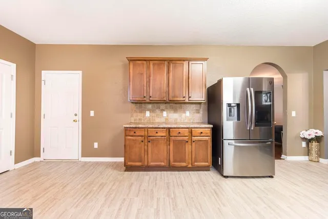 a kitchen with stainless steel appliances granite countertop a refrigerator a stove top oven and wooden floor