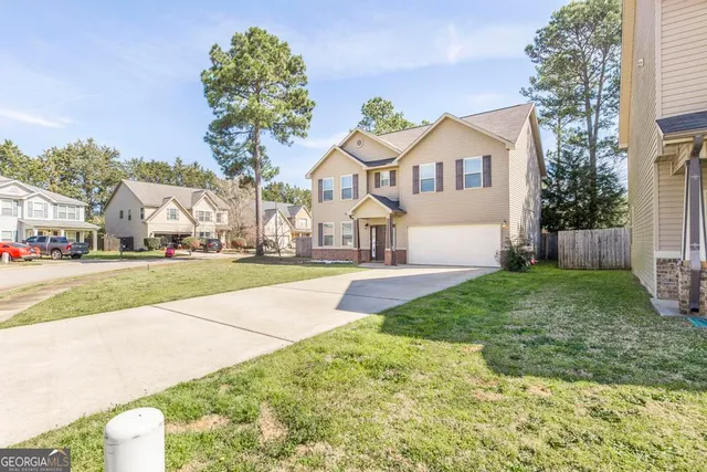 a front view of a house with a yard and potted plants