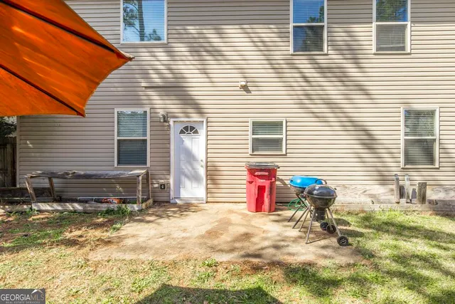 a view of a house with backyard and sitting area